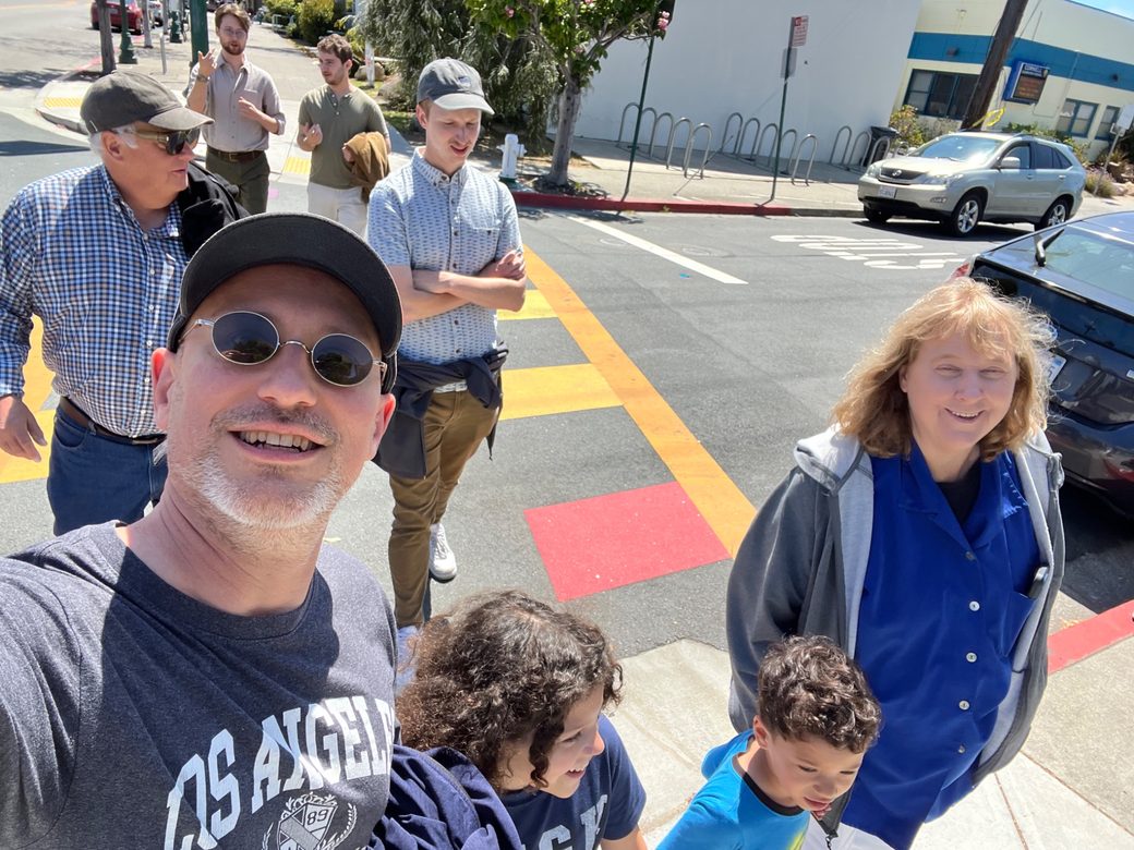 Cheryl and Peter with their families, together on a sunny street corner